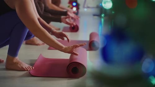 Yoga Practitioners Prepare Mats for a Session in a Serene Studio Space