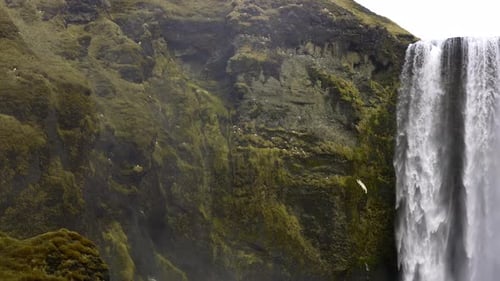 Majestic Waterfall Flowing Down Green Mossy Cliffs
