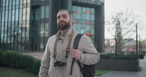 Man with Camera Walking in City Park