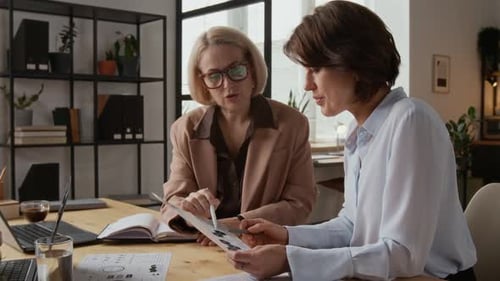 Two Middle-Aged Women Working with Business Documents in Modern Office