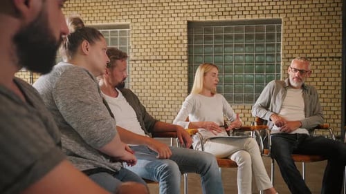 Adults Sit in Circle Discussing Corporate Workplace