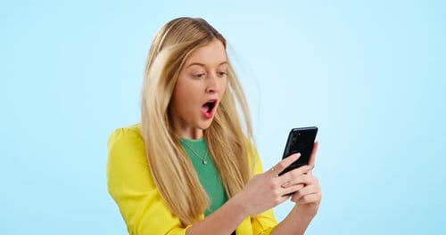 Surprise, wow and woman with phone in studio for wind, news or social media promo on blue