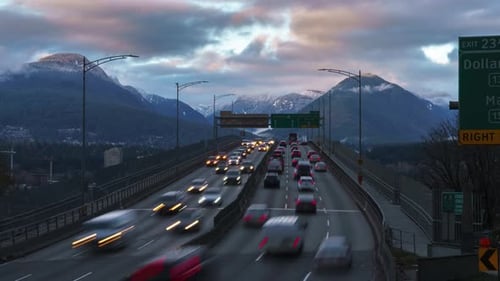 Zeitraffer eines dichten Verkehrs beim Überqueren einer Brücke mit Bergkulisse