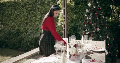 Woman Sets Festive Christmas Dinner Table Outdoors