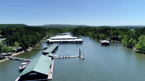 Drone flies above a beautiful lake and boathouses on a serene summer morning