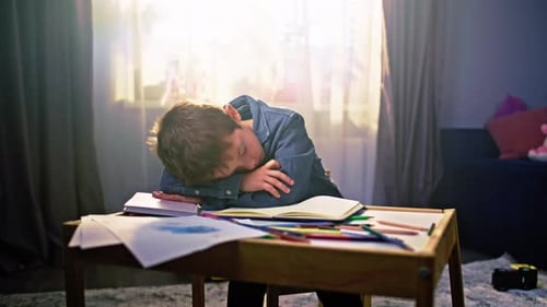Tired Child Sleeping at Desk at Home
