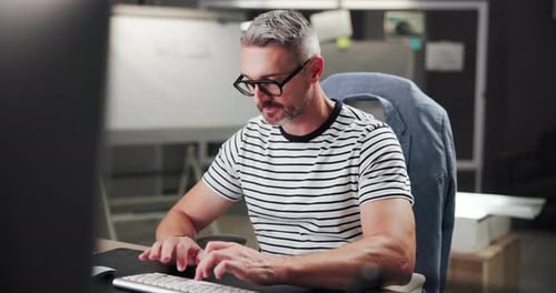 Man Typing at Computer in Modern Office Setting