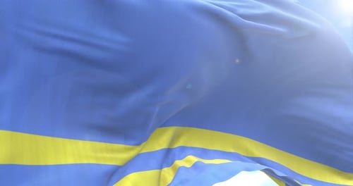 Realistic Waving Flag of Aruba on Blue Sky