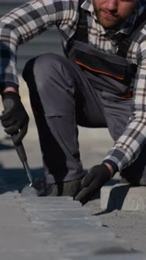 Construction Worker Laying Stones in Urban Setting