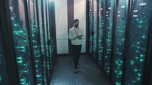 Man Uses Tablet in Data Center Server Room