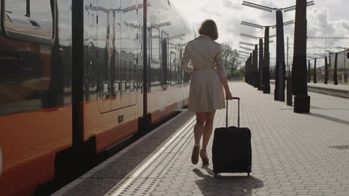 Confident Woman With Luggage Walking on Railway Station
