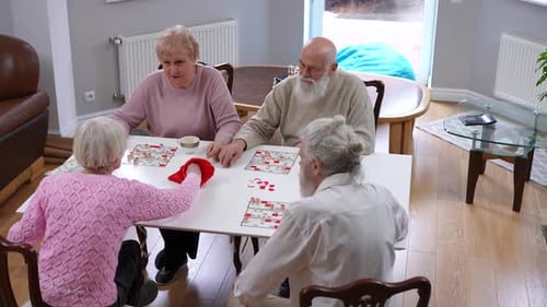 High Angle View Group of Curious Old Men and Women Playing Table Lotto Indoors Wide Shot Positive