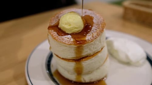 Sirup auf flauschige Pfannkuchen gießen