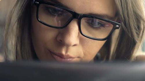 Young Woman Using Tablet Computer Sitting in Cafe 30s