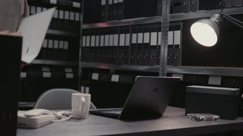 Man Drinking Coffee and Working on Laptop