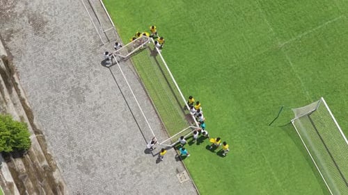 Aerial view of youth soccer team training on a green football pitch