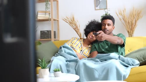 Couple Relaxing on Sofa Watching TV at Home