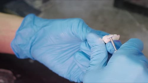 Dental Technician Works on Set of Teeth