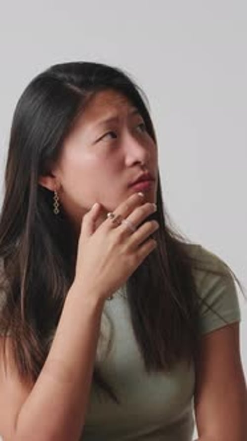 Young woman thinking and making decision isolated over white background in studio