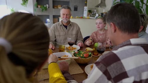 Group Eating Together at Table in Home
