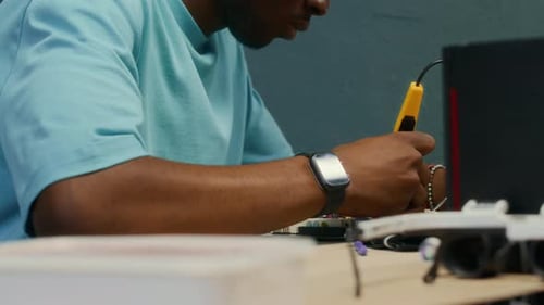 Mann der Generation Z repariert die CPU eines Computers mit einem Lötkolben