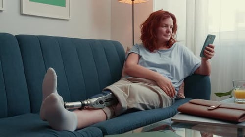 Happy Beautiful Successful Woman with Futuristic Bionic Prosthetic Leg Using Smartphone to Shop