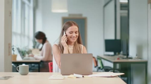 Woman talking on phone in modern office