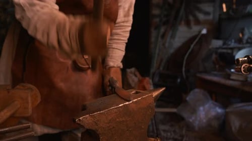 Turning iron. Media. Processionals work to shape the iron in with special hammers.