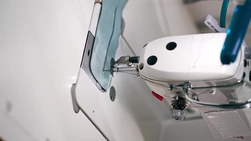 Vertikales Video, Nahaufnahme, professionelle chemische Reinigung, junges Mädchen, säumt einen Patch auf einem Pullover mit einer Naht