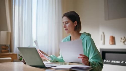 Smiling Lady Reading Paperwork at Home Workspace Closeup Happy Woman Satisfied
