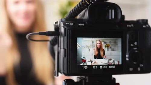Camera recording young adult in front of bright room