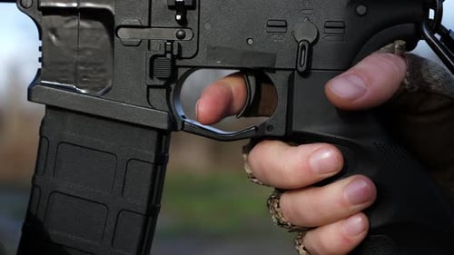 Gloved Hand Pulling Rifle Trigger Close Up