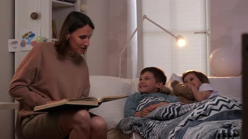 Woman Reads Bedtime Story to Happy Children