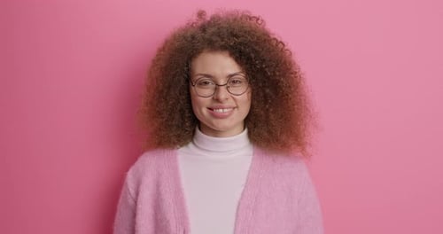 Smiling Woman with Curly Hair and Glasses