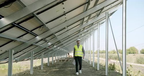 Male Engineer Inspecting Solar Panels