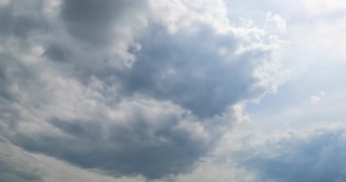 Formation of rain cloudscape in the atmosphere. Grey overcast sky from low angle view. Timelapse.