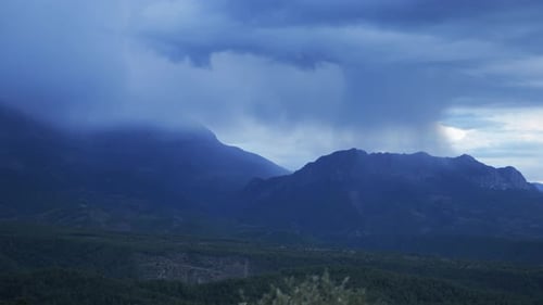 The General Plan is an Evening Shot of Rain in the Distance Over the Mountain
