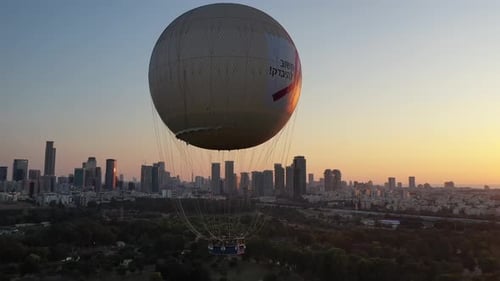 Aerial Shot Of Hot Air Balloon Descending Over Yarkon Park Against Sky In City