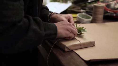 Hands Tying Twine Around a Gift