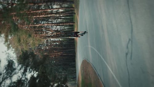 Aerial of Adult Riding Bike Along Curved Road