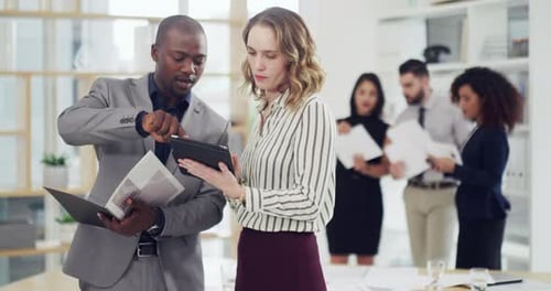 4k video footage of two businesspeople working together on a digital tablet in an office