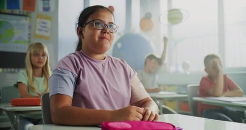 Primary School Girl Raising Hand and Giving Correct Answer on Teacher's Question During Lesson