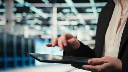Close Up of Data Center Cybersecurity Analyst Using Tablet to Conduct Audit