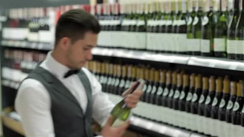 Young Man Selects White Wine in Store