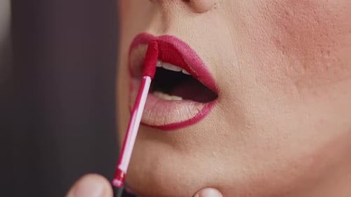 Woman Applying Red Lipstick with Applicator Close Up