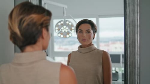 Portrait Of Woman Looking Mirror After Beauty Procedures In Luxury Cosmetology Clinic. Attractive...