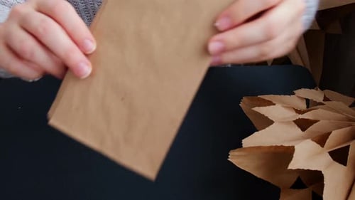 Woman Crafting Paper Ornament at Black Table