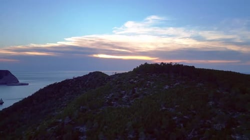 Ibiza Cala Benirras bay and coastline at sunset. Best aerial view flight drone