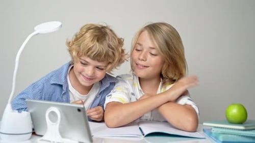 Middle Primary School Students Boy Girl Remotely Studying Writing Book Homework and Tablet at Class