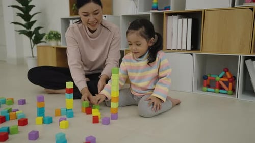 Woman and Girl Building Colorful Blocks Together Indoors